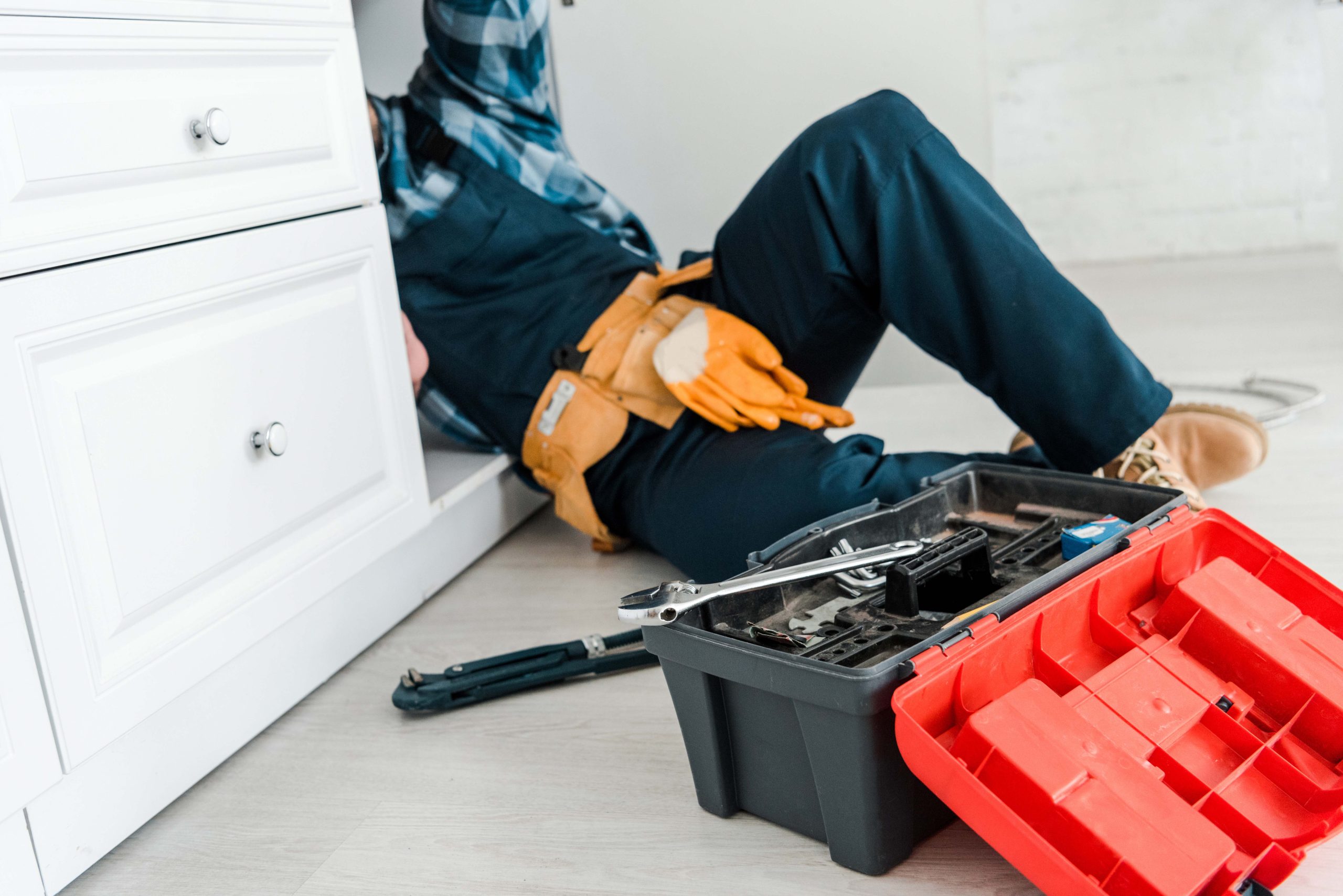 selective focus of repairman working near kitchen cabinet and to