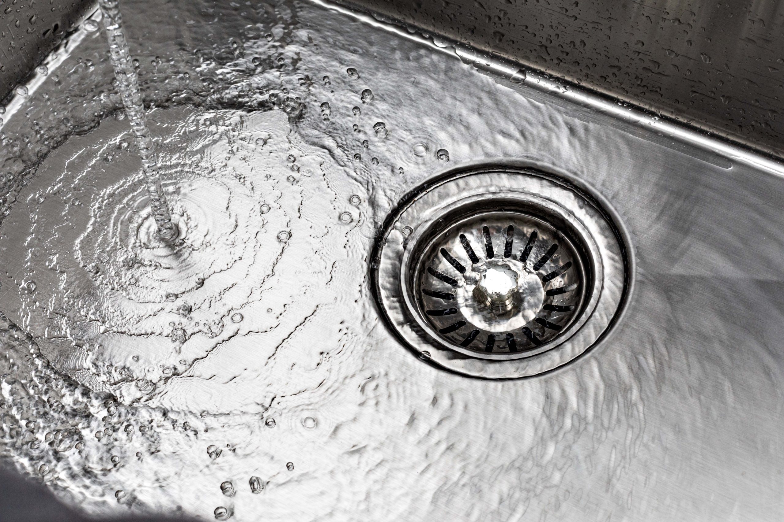 water drains down a stainless steel sink