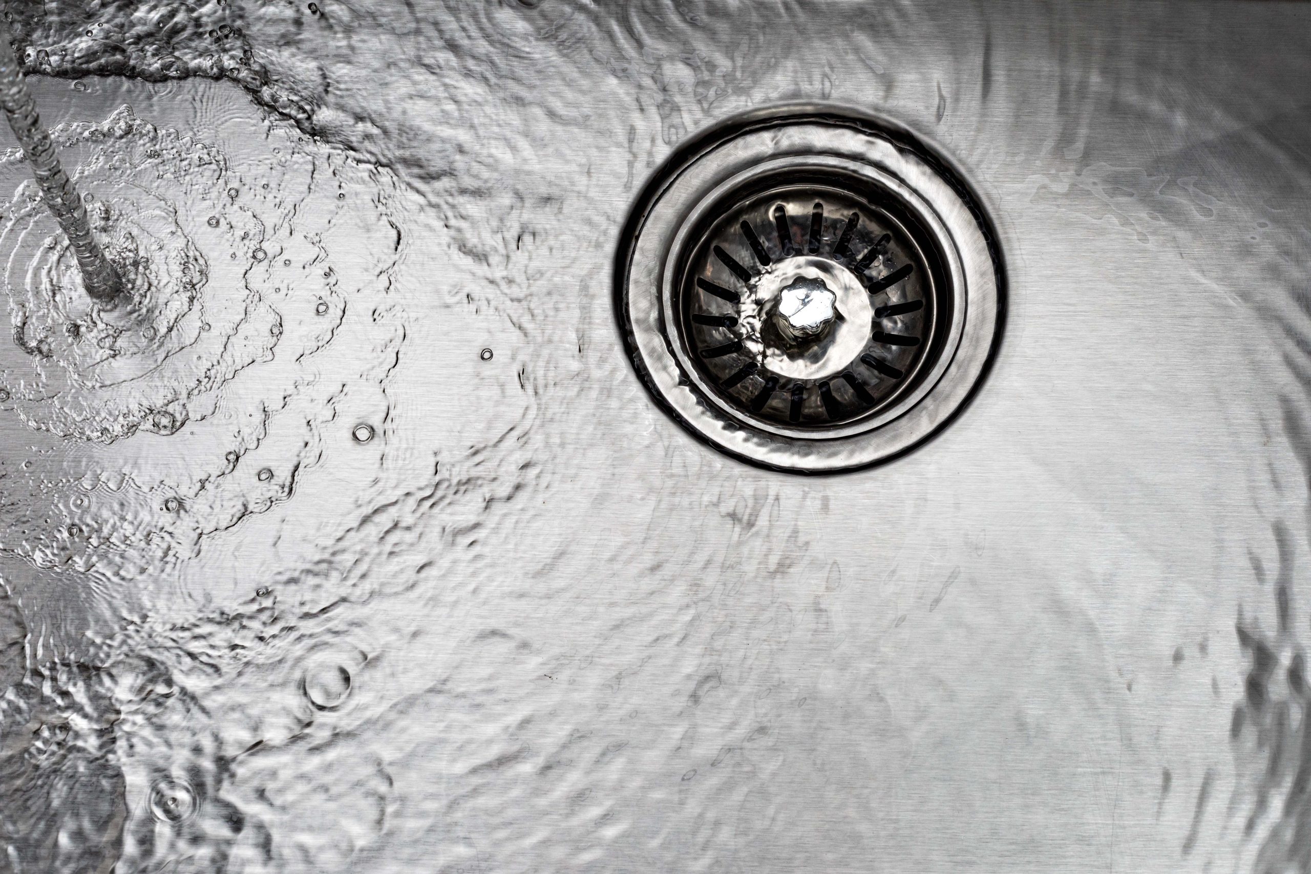 water drains down a stainless steel sink