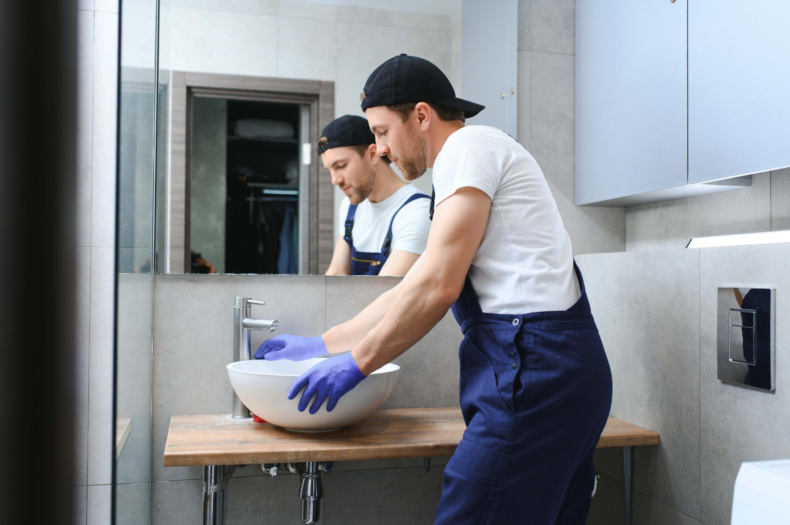 young handyman installing sink in bathroom