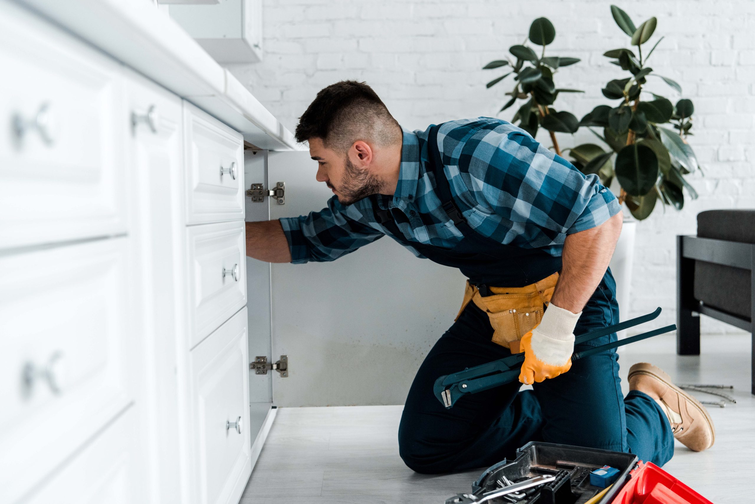 selective focus of bearded man working in kitchen near toolbox w